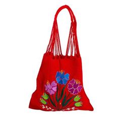 Chili red cotton hosts a bright bouquet of flowers embroidered on a colorful shoulder bag. The blossoms in Caribbean blue and purple with forest green foliage add to its festive feel. Working on the backstrap loom Petrona Perez and the Women Artisans Association craft the traditional Mexican morral a shoulder tote once used by both men and women. The warp threads are twisted then connected to become the shoulder strap. The reverse side is solid red. Red Embroidered Bag, Red Bohemian Cotton Bags, Bohemian Red Cotton Bags, Red Floral Embroidery Tote Shoulder Bag, Red Floral Embroidered Tote Shoulder Bag, Red Floral Embroidered Everyday Bags, Red Bohemian Cotton Shoulder Bag, Red Floral Embroidery Bag For Daily Use, Red Floral Embroidered Tote Bag