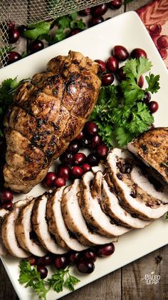 a white plate topped with sliced turkey and cranberries