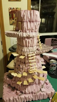 a cake made to look like a tower with many pieces of paper on the top