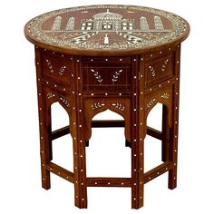 a wooden table with an intricate design on it's top and bottom, sitting against a white background