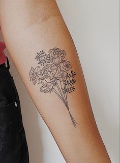 a person with a tattoo on their arm holding a bouquet of flowers in one hand