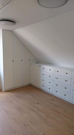 an empty room with white cabinets and drawers