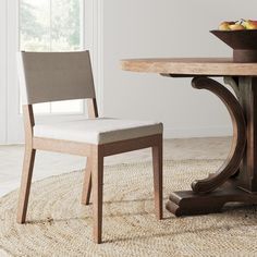 a dining room table with a bowl of fruit on it and a chair at the end