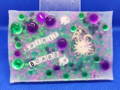 a close up of a plastic bag with beads on it and the words spinball board written in white