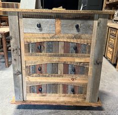 a wooden cabinet with several drawers and knobs on the front, in a store