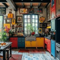 a kitchen with lots of colorful cabinets and pictures on the wall