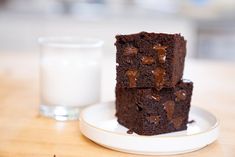 three pieces of chocolate cake on a plate next to a glass of milk