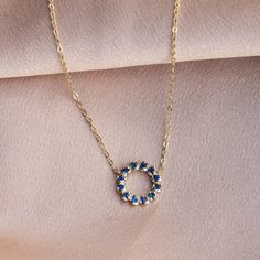 A minimalist circle pendant necklace with natural blue sapphire gemstones for women in 14K solid yellow gold. A great birthday gift for her.  D E T A I L S ● Metal: 14K solid gold, 14K white gold ● Gemstone: 12 Blue Sapphires, Round Cut, Natural ● Sapphire's Weight: 0.24 ct ● Length: 16 inches - 41 cm H O W ∙ T O ∙ O R D E R Choose from the drop-down menu the available options (Metal) and leave us a note for any special requirements. G I F T S All our pieces are delivered beautifully packaged and gift ready with a certificate of authenticity for the metal and the stones.  P R O D U C T I O N ∙ T I M E * S H I P P I N G * P O L I C I E S Please keep in mind that each item is handcrafted, and we need 5 days at least for its production. If you need your order on a specific date, please contac Round Sapphire Birthstone Necklace As Gift, Yellow Gold Sapphire Birthstone Necklace, Yellow Gold Sapphire Round Birthstone Necklace, 14k Gold Sapphire Halo Jewelry, 14k Gold Sapphire Jewelry With Halo Detail, 14k Gold Sapphire Jewelry With Halo, Sapphire Halo Jewelry In 14k Gold, 14k Gold Sapphire Birthstone Necklace, 14k Gold Sapphire Necklace