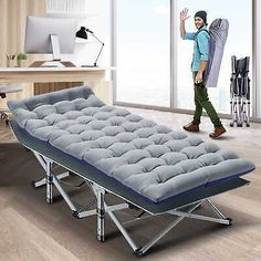 a man walking past a blue futon bed in an office