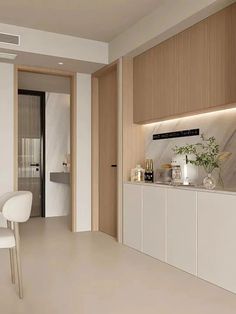 a kitchen with white cabinets and marble counter tops, along with an open door leading to the dining room