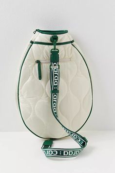 a white purse with green trim on the bottom and strap hanging from it's side