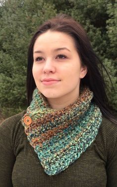 a woman wearing a green sweater and a crocheted cowl