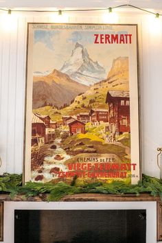 there is a large poster on the wall above a fireplace in this living room that has been decorated with garlands and lights