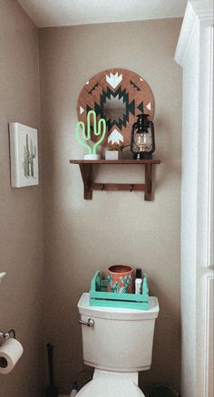 a white toilet sitting in a bathroom next to a wooden shelf