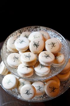 a glass plate filled with macaroons on top of a wooden table