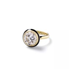 a gold and white diamond ring on a white background, with the center stone surrounded by black band