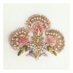 a brooch with pearls and leaves on it