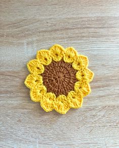 a crocheted sunflower sitting on top of a wooden table