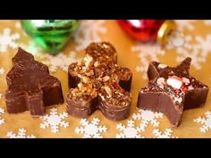 three pieces of chocolate sitting on top of a table next to christmas decorations and baubles