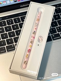 an open laptop computer sitting on top of a desk next to a pink and white toothbrush