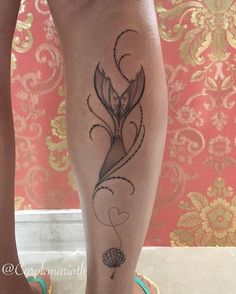 a woman's leg with a tattoo on it and a flower in the center