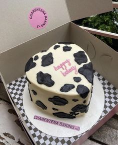 a birthday cake with black and white spots in a box