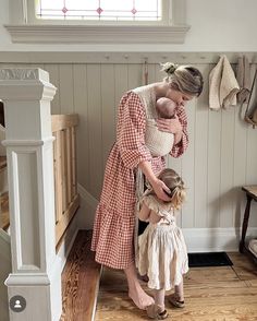 a woman holding a baby in her arms while standing next to a child's head