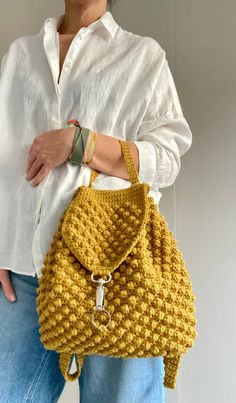 a woman is holding a yellow handbag