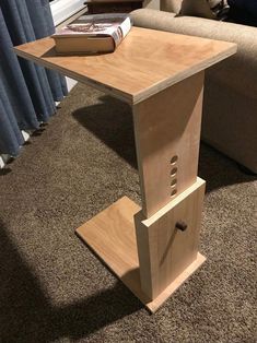 a wooden table sitting on top of a carpeted floor next to a couch and window