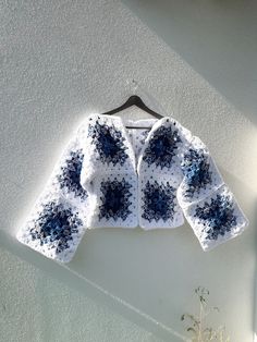 a crocheted jacket hanging on a wall