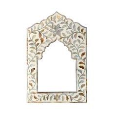 an ornate white mirror with leaves on it