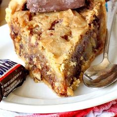 a piece of pie on a plate with a fork and chocolate bar in the background