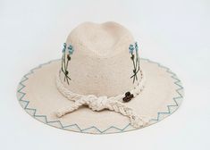 The wait is over! This hat is Ready to Ship and your order will be processed and shipped within 3-7 business days. Items with embroidery customization will be shipped within 2 weeks. Our exclusive LoveShackFancy inspired design! White Palm Straw Hat with Blue Bouquet by Corazon Playero. Custom designed and hand made hats by artisans in San Jose Del Cabo, Mexico. These hats are one size fits most with an elastic band inside to add comfort and fit for all head sizes. Please note, all hats come with natural braid unless custom braid is purchased. San Jose Del Cabo Mexico, Custom Made Hats, Cabo Mexico, Natural Braids, San Jose Del Cabo, Festival Costumes, I Love The Beach, Unique Hats, Blue Bouquet