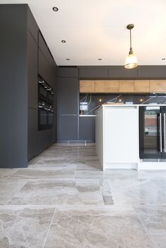 an empty kitchen with grey walls and flooring