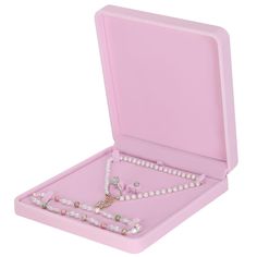 a pink jewelry box with pearls and a cross