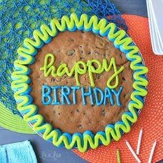 a cookie birthday cake with the words happy birthday spelled in blue and green icing