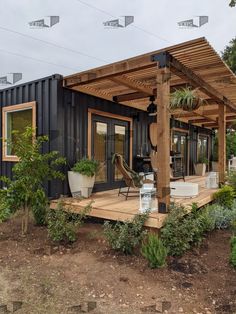 a house made out of shipping containers with a covered porch and patio area next to it