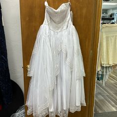 a white dress hanging on a wooden door