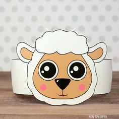 a paper sheep with big eyes on it's head