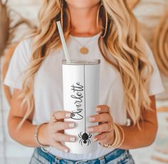 a woman holding a white tumbler cup with a straw in her hand