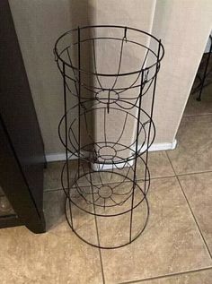 three tiered metal basket sitting on the floor