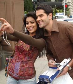 a man and woman taking a selfie on the street