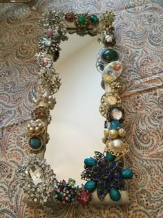 a mirror that is sitting on top of a table covered in jewels and other jewelry