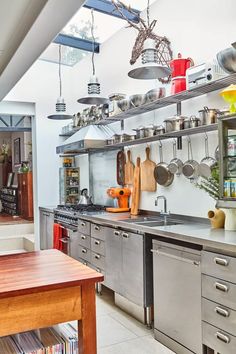 a kitchen with stainless steel appliances and shelves filled with pots, pans, and other cooking utensils