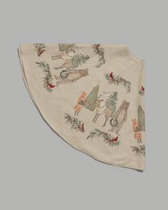 a white bandana with animals and pine branches on the front, hanging from a gray wall