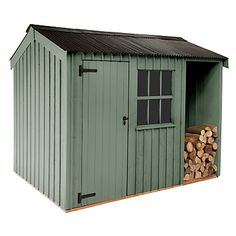 a green shed with logs stacked in it