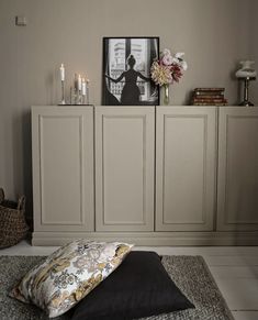 a bed with pillows and candles on top of it in front of a wall cabinet