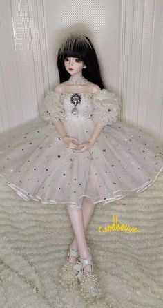 a doll is dressed in a white dress