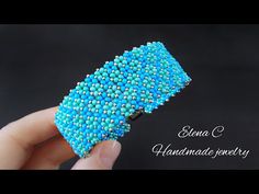 a hand holding a blue beaded bracelet