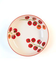 a white plate with red flowers and green stems painted on the side, against a white background